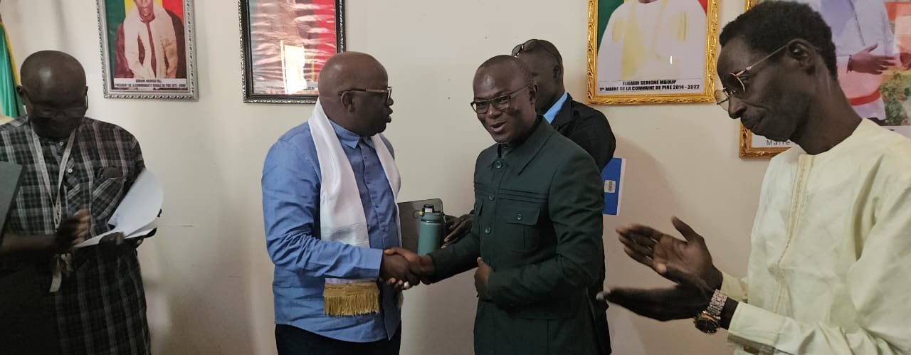 Échange de poignée de main entre le Recteur et le Maire de Pire en présence de la délégation